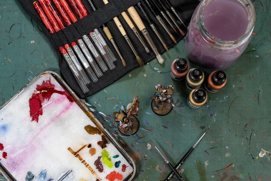 Miniature brushes and paints on a table