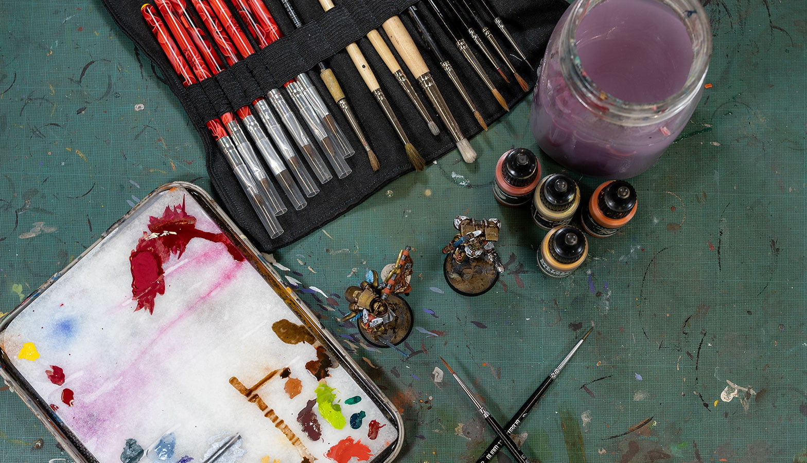 Miniature brushes and paints on a table